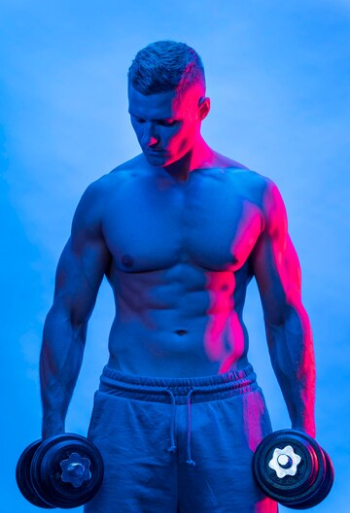 Спортивный мужчина держит гантели